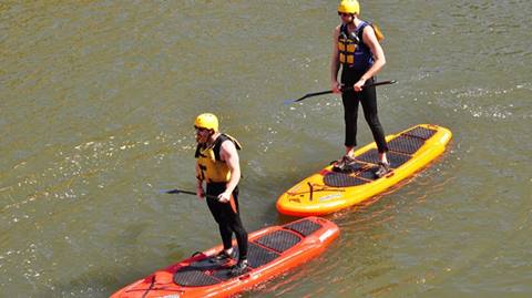 Two people enjoying stand up paddleboards.
