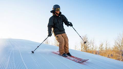 A skier on a groomed trail.