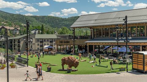 People enjoying the sunshine outside of The Range Food & Drink Hall at the base of Steamboat Resort.