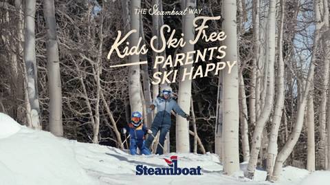 A family skiing through aspen trees.