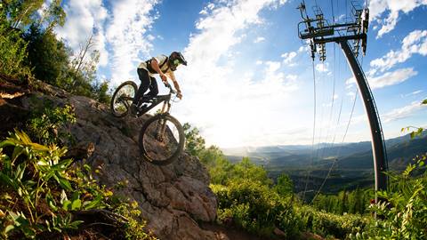 A mountain biker enjoying the Steamboat Bike Park in sunny weather.