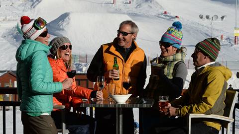 A group of friends enjoying aprés ski at the base area